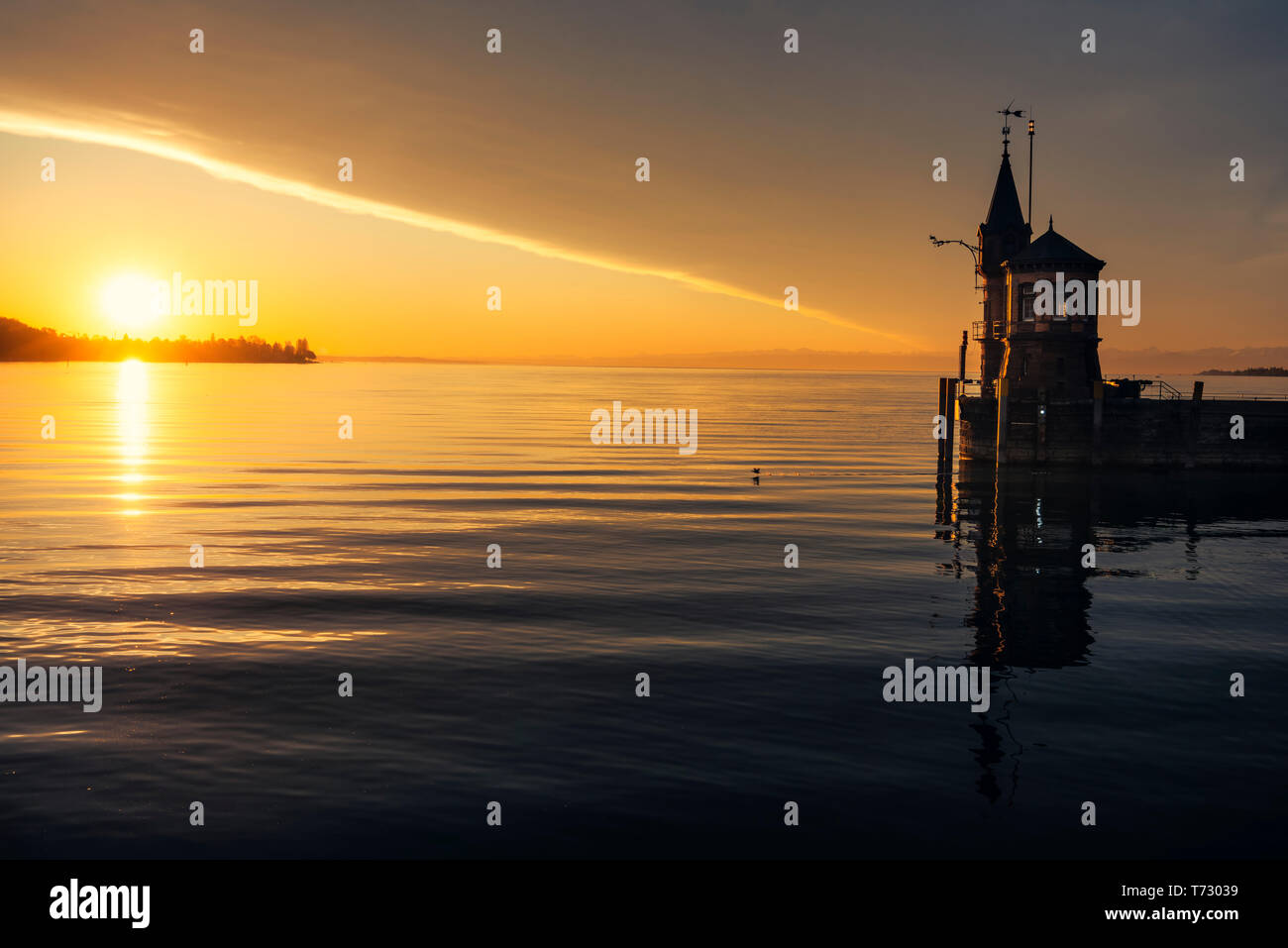 Am frühen Morgen auf dem Bodensee und einen kleinen Leuchtturm. Sunrise spiegelt sich in Wasser See in Konstanz, Deutschland. Entspannende Landschaft. Stockfoto