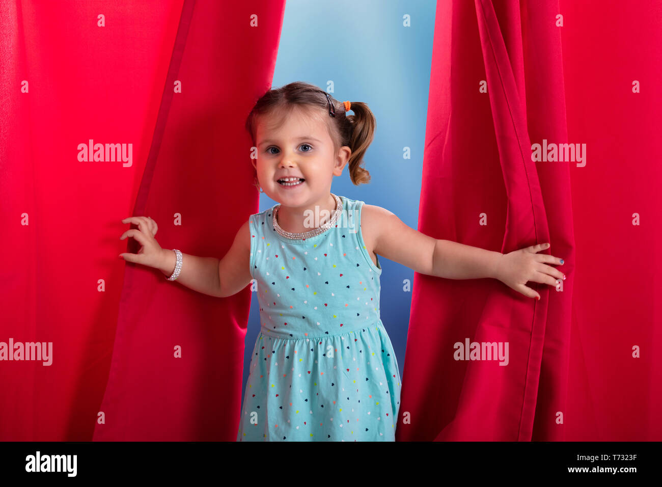 Portrait von Hübsches Mädchen Aus roten Vorhang auf der Suche Stockfoto