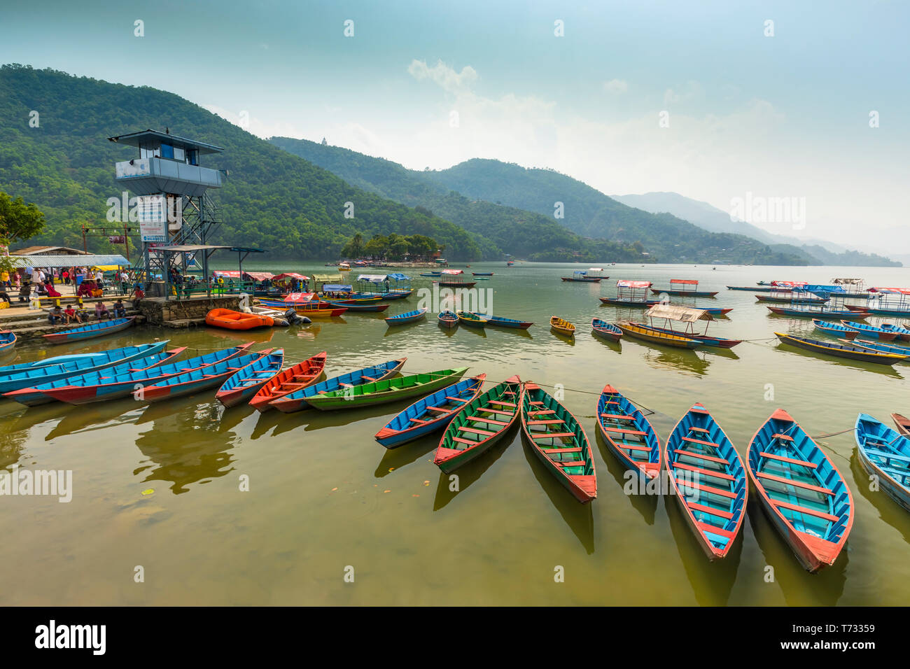 Tolle Aussicht auf Phewa See. bunte Boote Halt am Mittag 28-04-2019 in die Warteschlange eingereiht. Mitte Masse Watch Tower und Hintergrund grüne Hügel. Pokhara Nepal Stockfoto