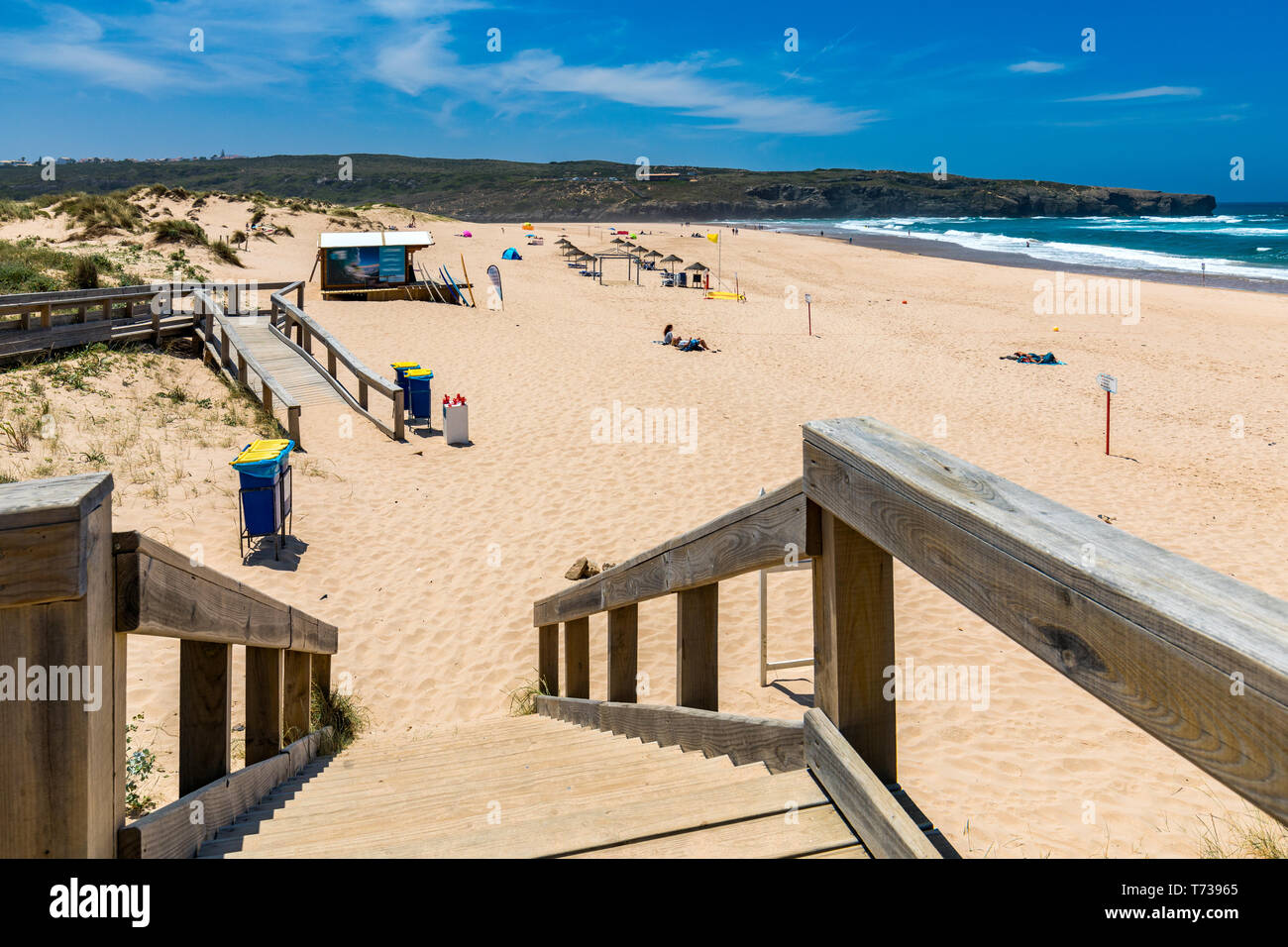 Holzsteg zum Strand Praia da Amoreira, Bezirk Aljezur, Algarve, Portugal. Panorama von Amoreira Strand an der Algarve, Portugal. Strand und Est Stockfoto