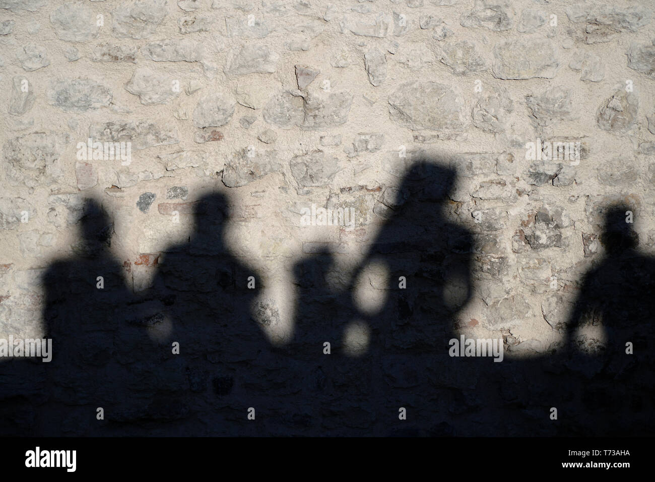 Die Schatten der Menschen auf der Mauer aus Stein Stockfoto