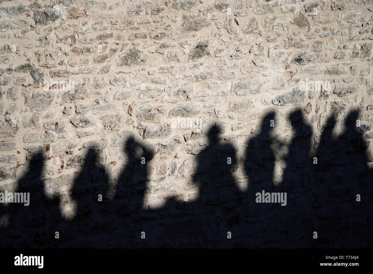 Die Schatten der Menschen auf der Mauer aus Stein Stockfoto