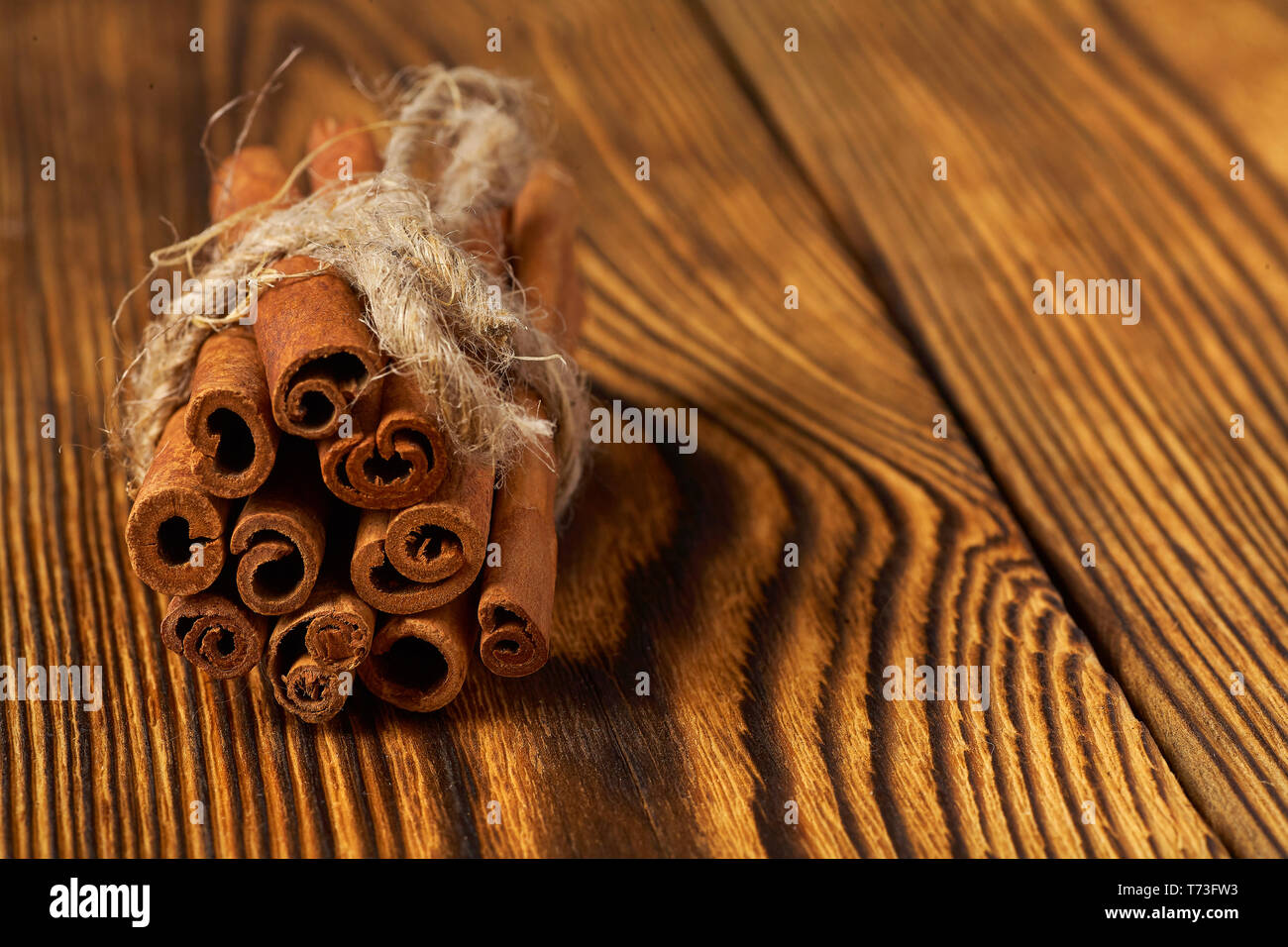 Bündel von Zimt mit einem Seil auf einer hölzernen Hintergrund gebunden. Stockfoto