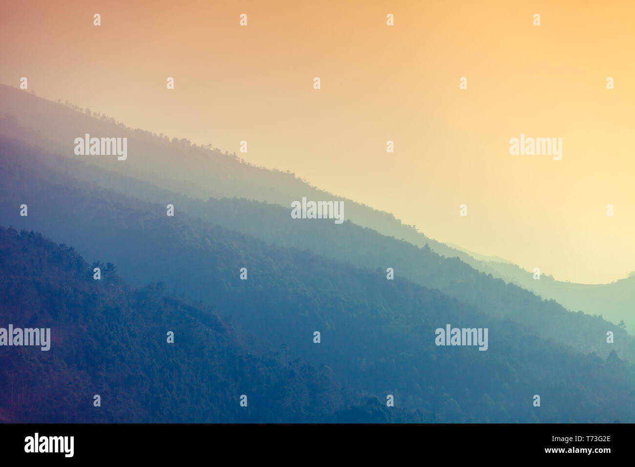 Gebirge in den frühen nebeliger Morgen. Sonnenaufgang über den Bergen Stockfoto