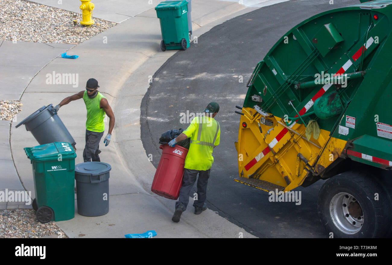 Zwei Abfallwirtschaft Arbeiter leer grün und grau Kunststoff Abfalleimer in einem Wohngebiet, Castle Rock Colorado USA. Foto im April getroffen. Stockfoto