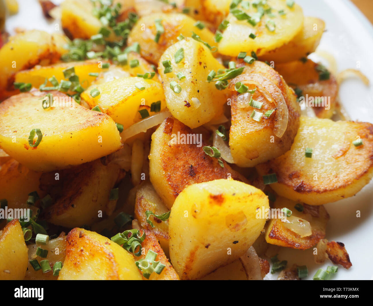 Köstlich knusprige Bratkartoffeln, garniert mit Schnittlauch Stockfoto