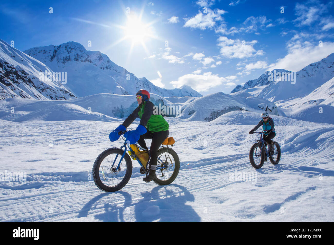 Zwei Frauen fat Bike vor skookum Gletscher, Chugach National Forest, Alaska an einem sonnigen Wintertag, South-central Alaska Stockfoto