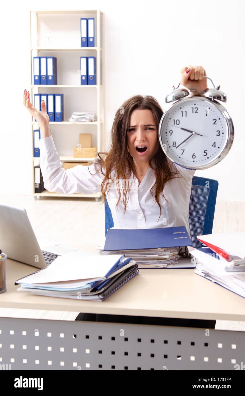 Junge weibliche Mitarbeiter mit übermäßiger Arbeit unzufrieden Stockfoto