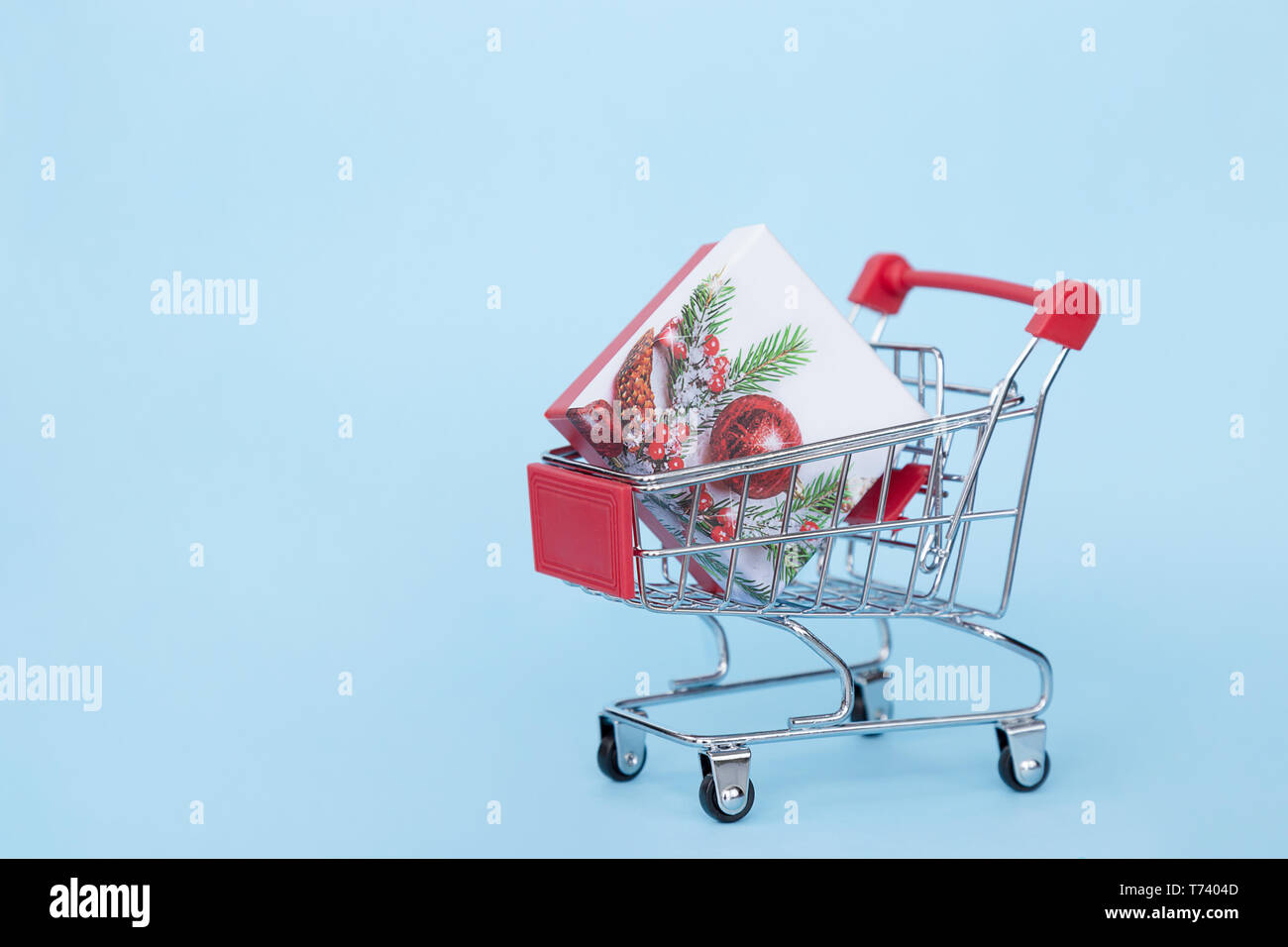 Weihnachten Geschenke in einem Supermarkt Trolley auf blauem Hintergrund mit Freiraum für Text Stockfoto