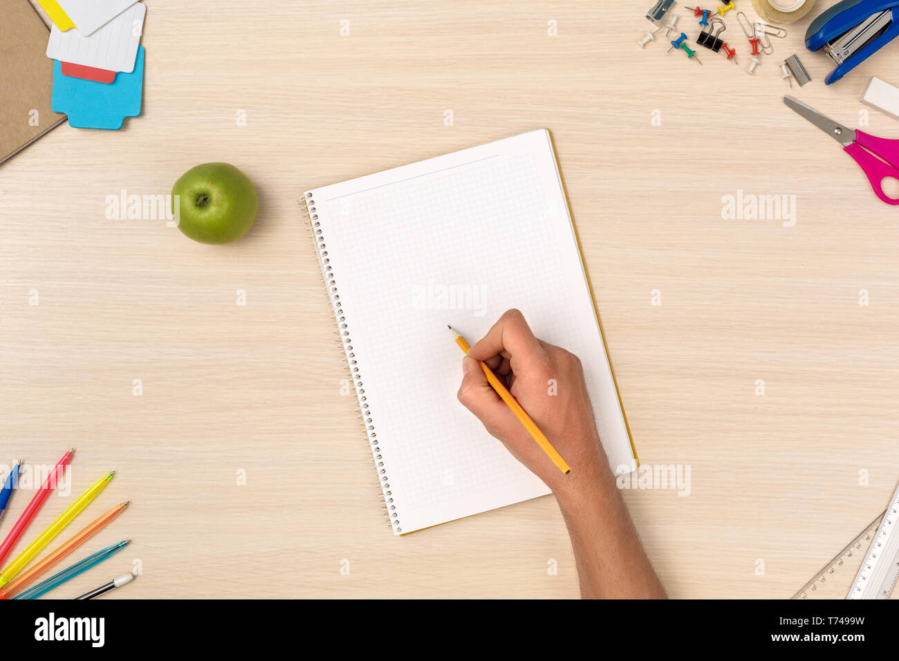Holz- Schreibtisch Arbeitsplatz Draufsicht person Hausaufgaben im Notebook close-up Stockfoto