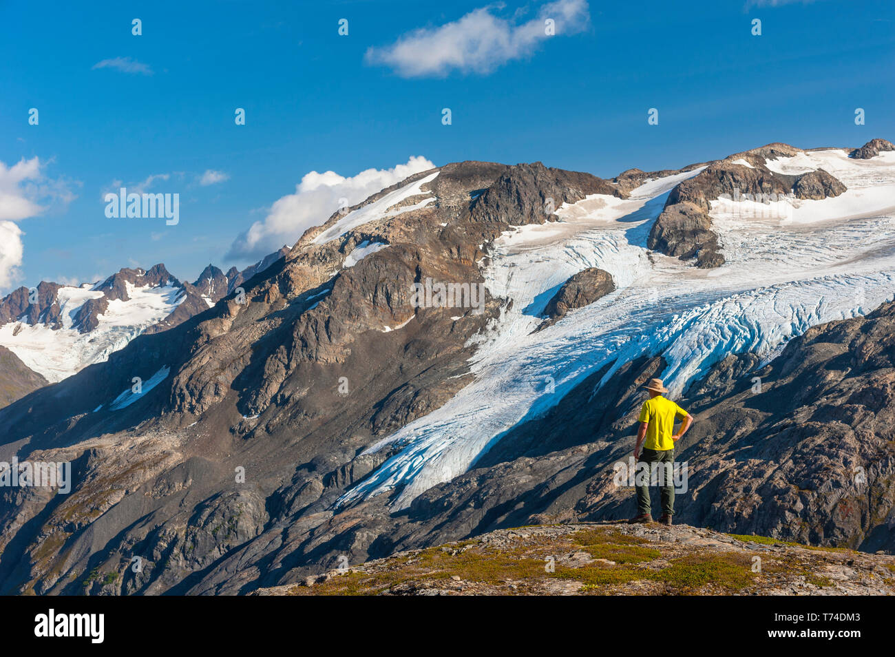 Der Kenai Fjords National Park, ein Mann, der in der Nähe des Harding Icefield Trail mit den Kenai Mountains und einem namenlosen hängenden Gletscher... Stockfoto