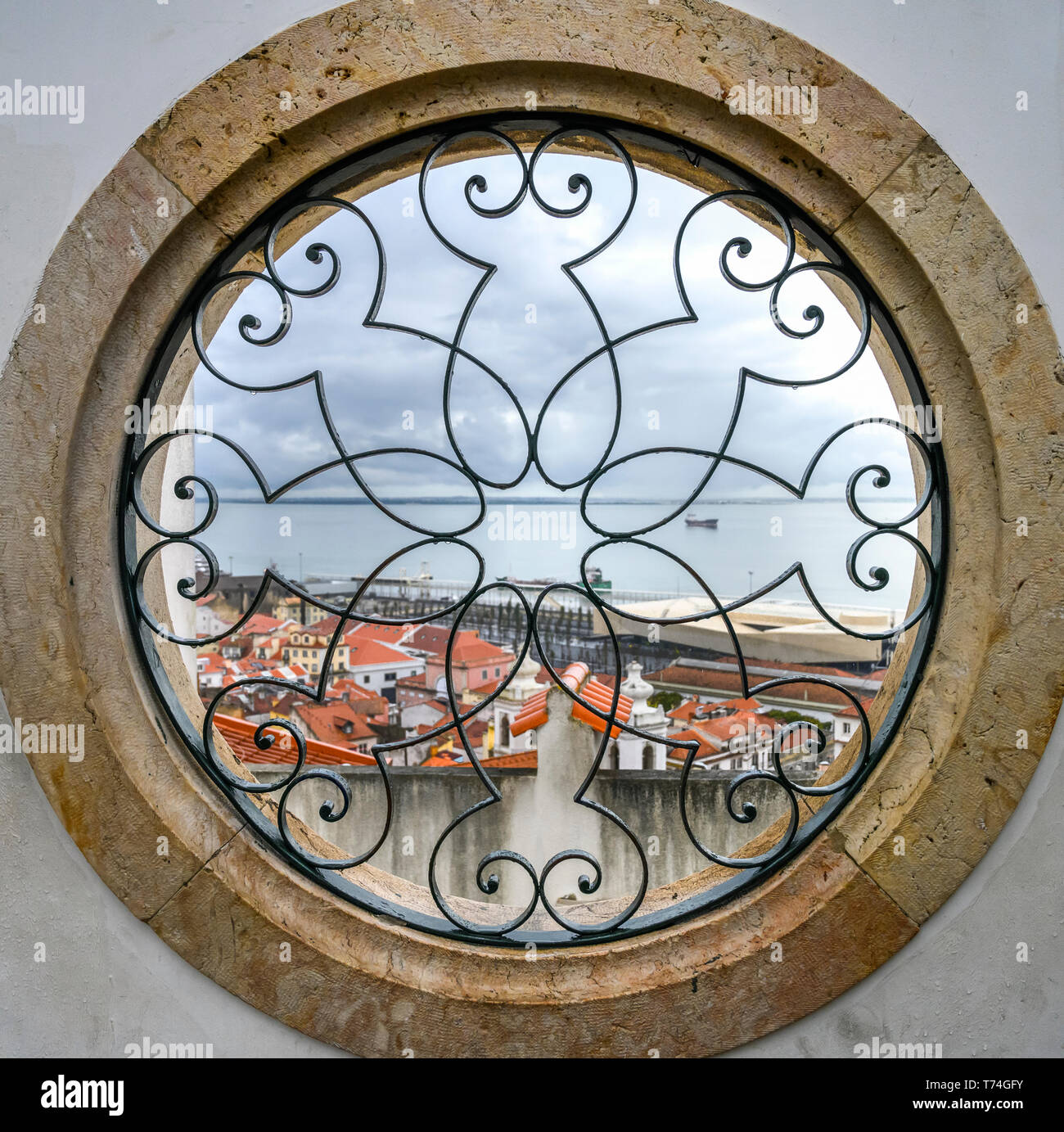 Blick durch ein rundes Fenster über den Fluss Tajo und Alfama vom Miradouro de Santa Luzia; Lissabon Region Lissabon, Portugal Stockfoto