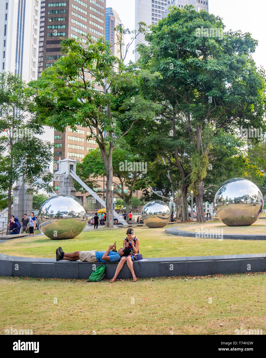 Romantisches Paar durch Edelstahl Kugeln 24 Stunden in Singapur durch Baet Yeok Kuan Bildhauer im Garten von Asian Civilisations Museum in Singapur. Stockfoto