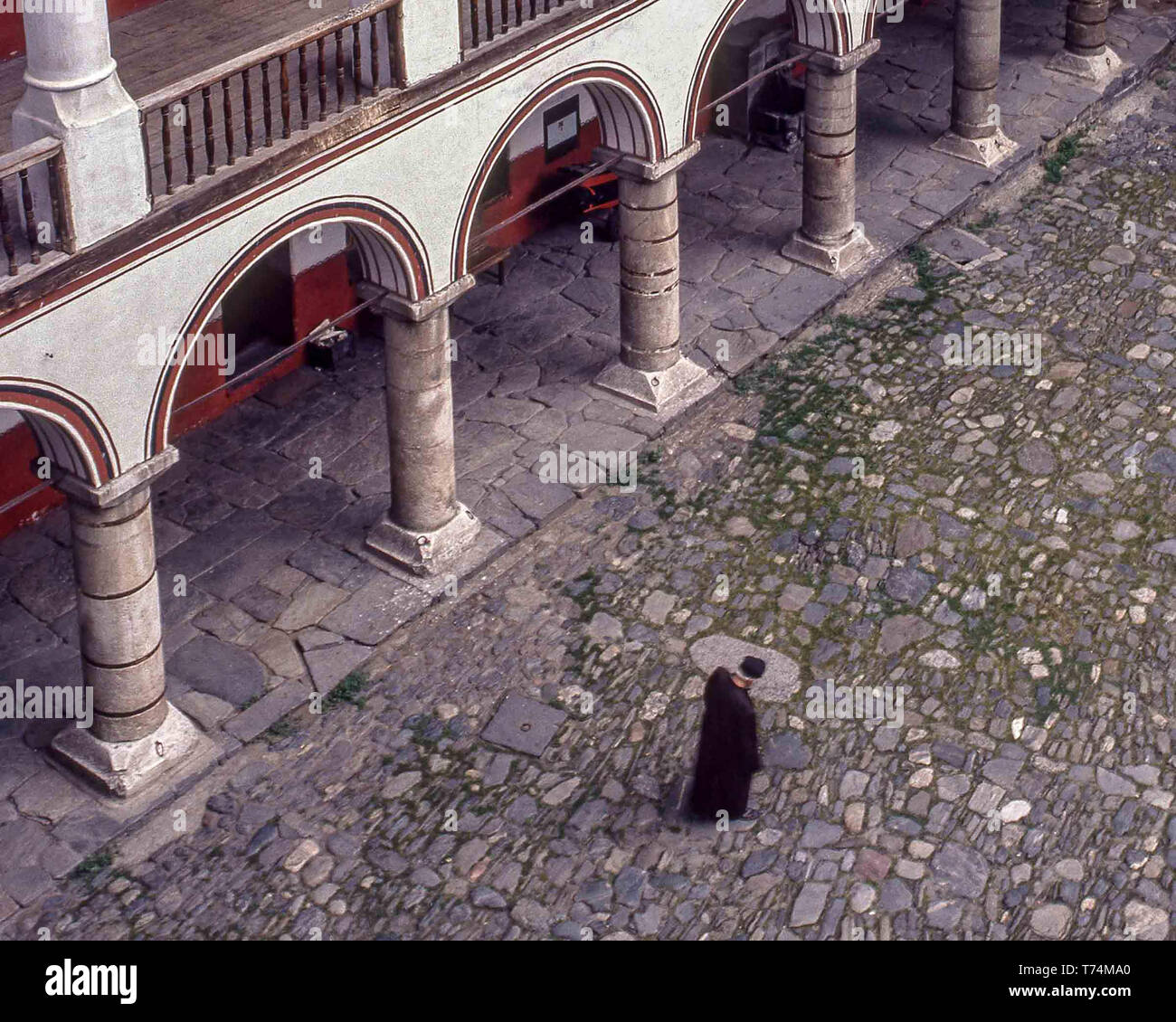 In Burgas, Bulgarien. 1 Aug, 1991. Ein Mönch, mit gesenktem Kopf, Spaziergänge in den Innenhof des 10. Jahrhunderts Rila Kloster (Kloster des Hl. Ivan von Rila), der größten und berühmtesten Bulgarischen Orthodoxen Kloster, in der südwestlichen Rila-gebirge, ist im Inneren von Rila Kloster Nature Park. Bulgarien einer der wichtigsten kulturellen, historischen und architektonischen Denkmälern es ist die Heimat von etwa 60 Mönche und ist eine wichtige Touristenattraktion für Bulgarien und Südeuropa. Credit: Arnold Drapkin/ZUMA Draht/Alamy leben Nachrichten Stockfoto