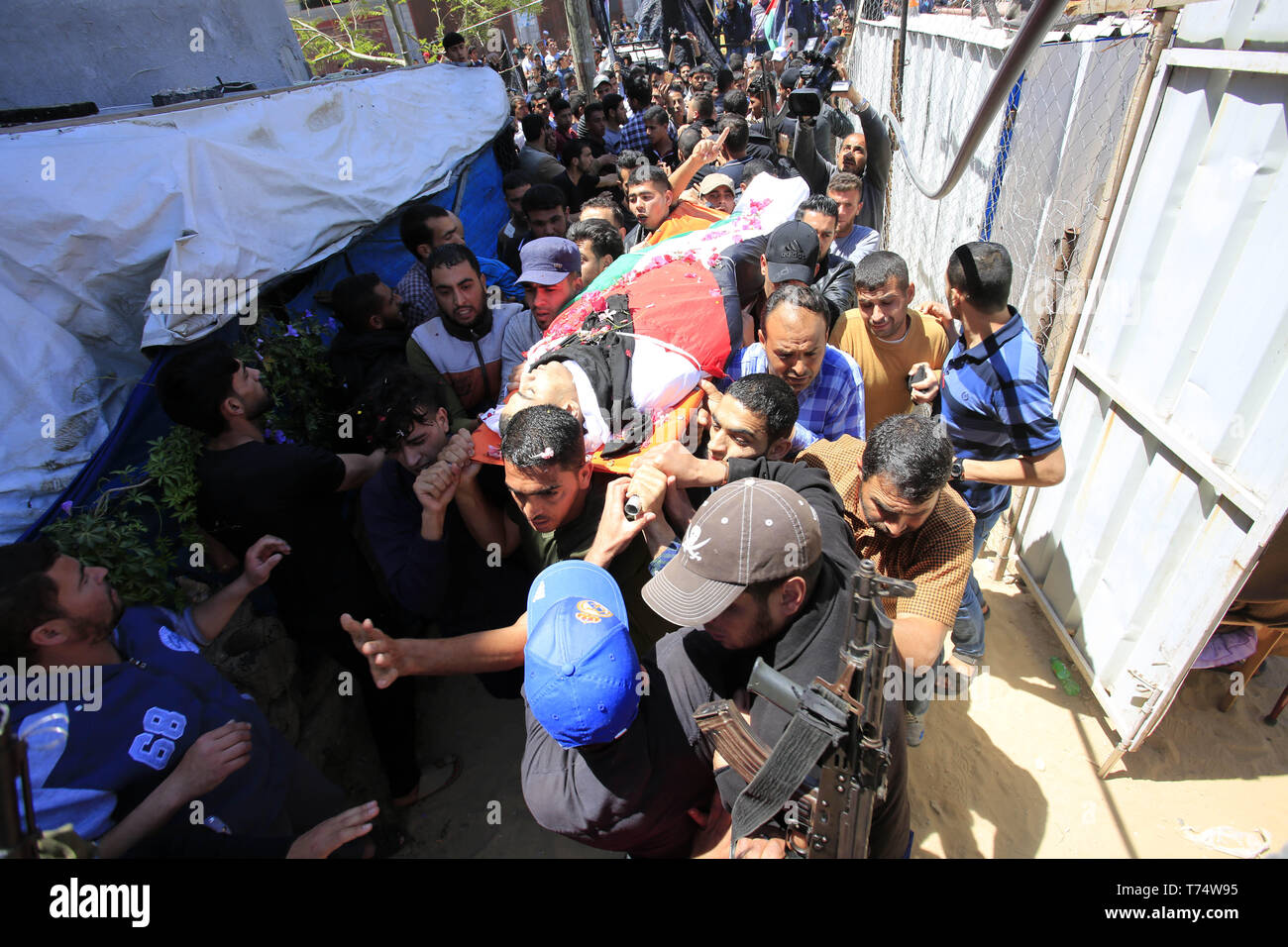 Gaza, Gazastreifen, palästinensischen Gebiet. 4. Mai, 2019. Trauernde tragen die Körper der Palästinensischen Raed Abu Tair, während eines Protestes auf der Israel-Gaza Grenzzaun, während seiner Beerdigung in Khan Yunis im südlichen Gazastreifen am 4. Mai 2019 getötet. Berichten zufolge fünf Palästinenser getötet wurden, darunter drei, die sich in israelischer Luftangriffe im Gazastreifen und zwei während der Proteste nach dem Freitagsgebet in der Nähe der Grenze mit Israel östlichen Gazastreifen Credit: Ramadan El-Agha/APA-Images/ZUMA Draht/Alamy leben Nachrichten Stockfoto