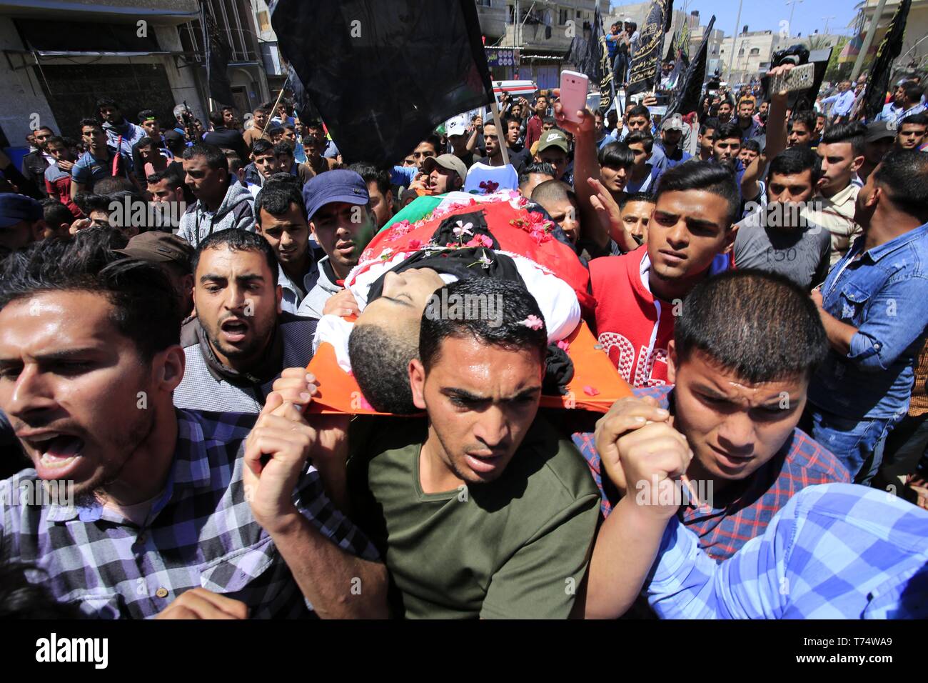 Gaza, Gazastreifen, palästinensischen Gebiet. 4. Mai, 2019. Trauernde tragen die Körper der Palästinensischen Raed Abu Tair, während eines Protestes auf der Israel-Gaza Grenzzaun, während seiner Beerdigung in Khan Yunis im südlichen Gazastreifen am 4. Mai 2019 getötet. Berichten zufolge fünf Palästinenser getötet wurden, darunter drei, die sich in israelischer Luftangriffe im Gazastreifen und zwei während der Proteste nach dem Freitagsgebet in der Nähe der Grenze mit Israel östlichen Gazastreifen Credit: Ramadan El-Agha/APA-Images/ZUMA Draht/Alamy leben Nachrichten Stockfoto