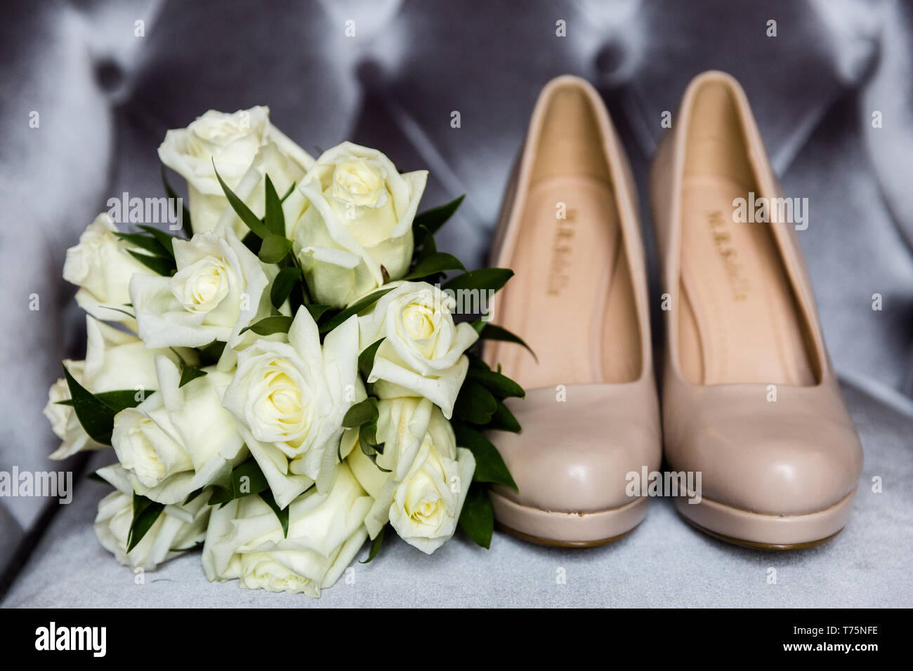 Brautstrauß aus weissen Rosen neben High Heel Schuhe der Braut Stockfoto