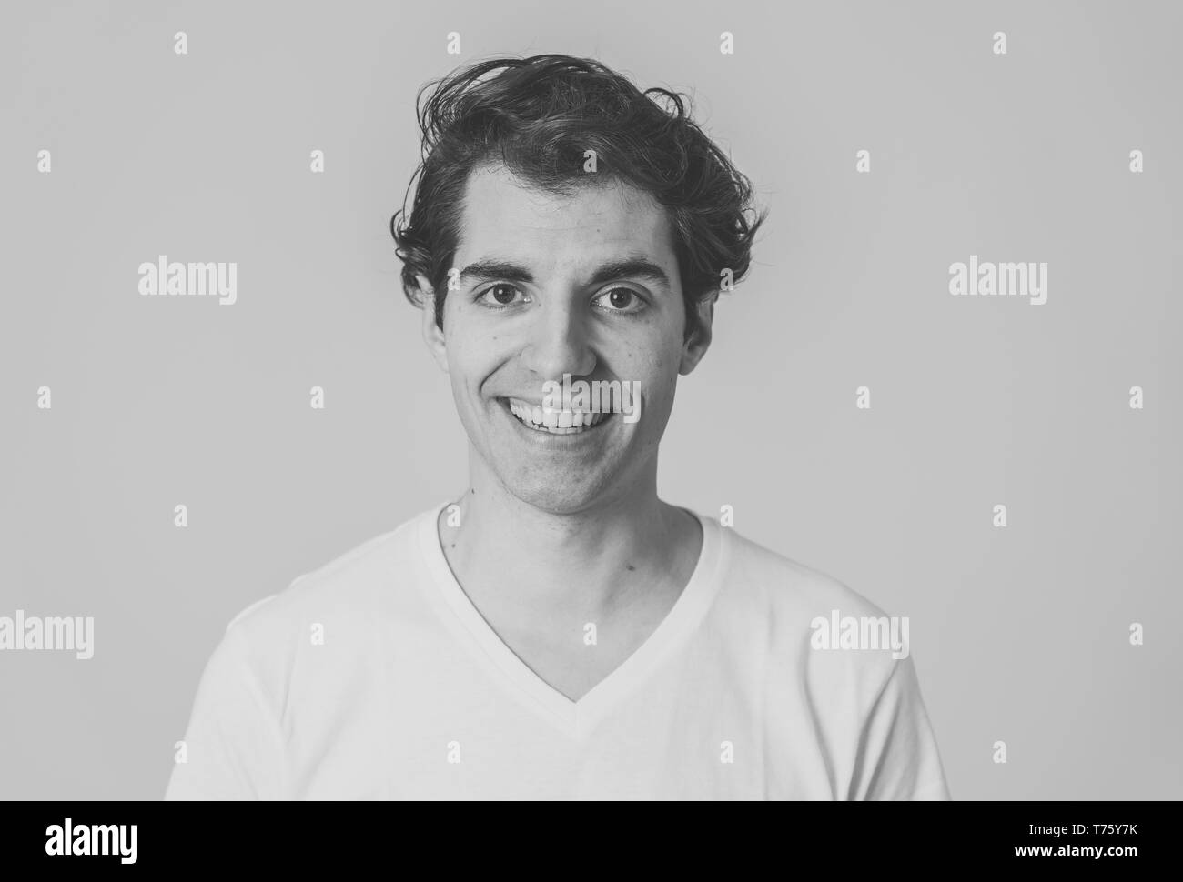 Close up Portrait von glücklichen jungen kaukasischen latin Mann mit weissen T-Shirt. Lächelnd Gefühl zufrieden und zuversichtlich. Mit kopieren. Menschen, positive Stockfoto