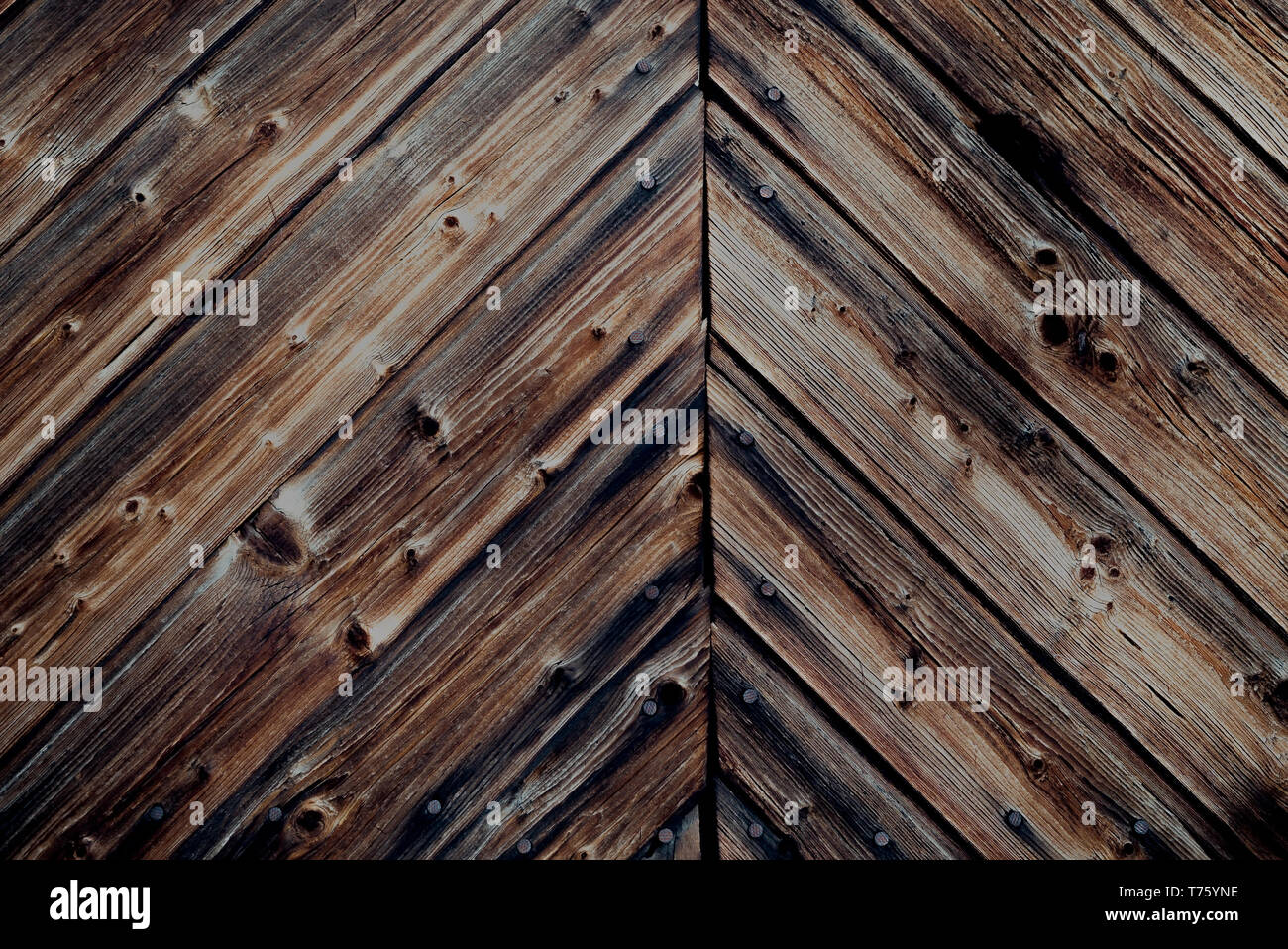 Rustikale dunkle antike gebeizt Wand mit alten, gerissenen Holzbohlen und Nägel in die Landschaft - Grunge vintage Oberfläche Hintergrund mit Copyspace Stockfoto