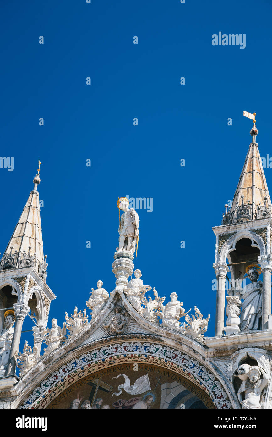 In der Nähe der Statuen auf der Spitze der Basilika di San Marco, St Mark's Basilika in Venedig, Italien. Golden luxus Detail der Fassade im Sommer gegen den blauen Sk Stockfoto