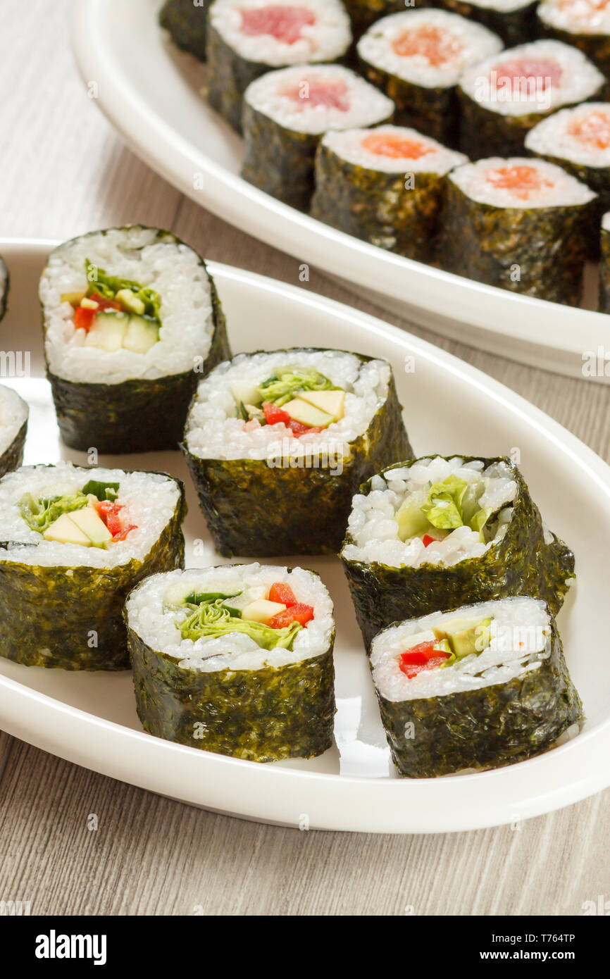 Verschiedene sushi Rollen mit Reis und Algen Blätter auf keramischen Platten. Ansicht von oben. Stockfoto