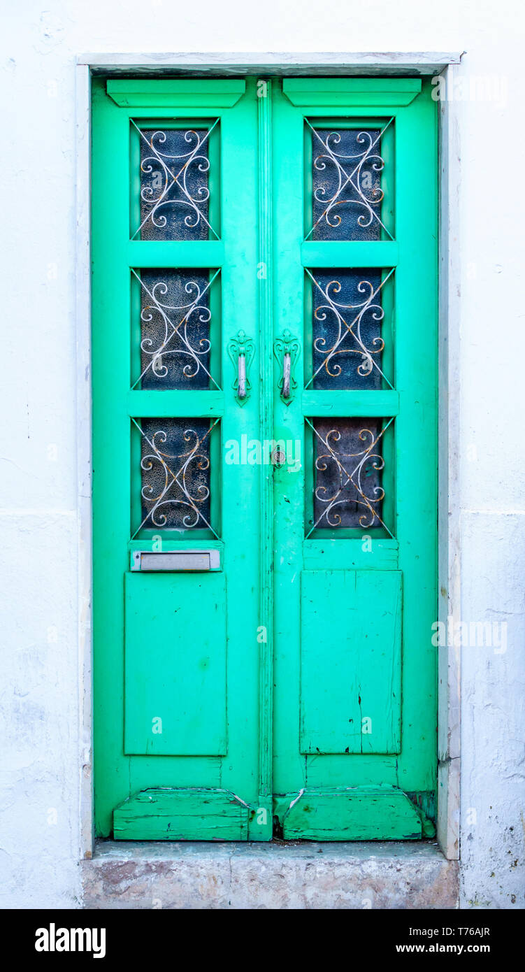 Traditionelle portugiesische vordere Tür mit pulsierenden grüne Farbe in verwitterten Fassade - vertikale Ausrichtung im Hochformat Stockfoto