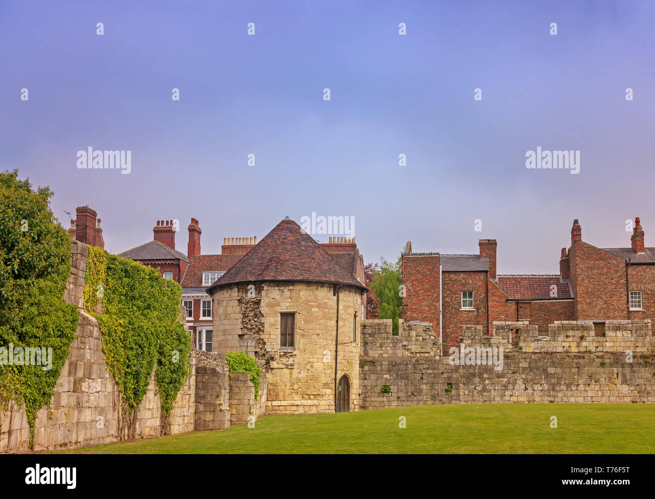 Alte runde Turm in Stadtmauern von York. Die Häuser sind auf der anderen Seite und Es ist ein bewölkter Himmel oben. Stockfoto