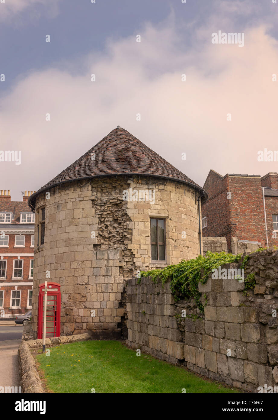 Alte runde Turm in Stadtmauern von York. Die Häuser sind auf der anderen Seite und Es ist ein bewölkter Himmel oben. Stockfoto