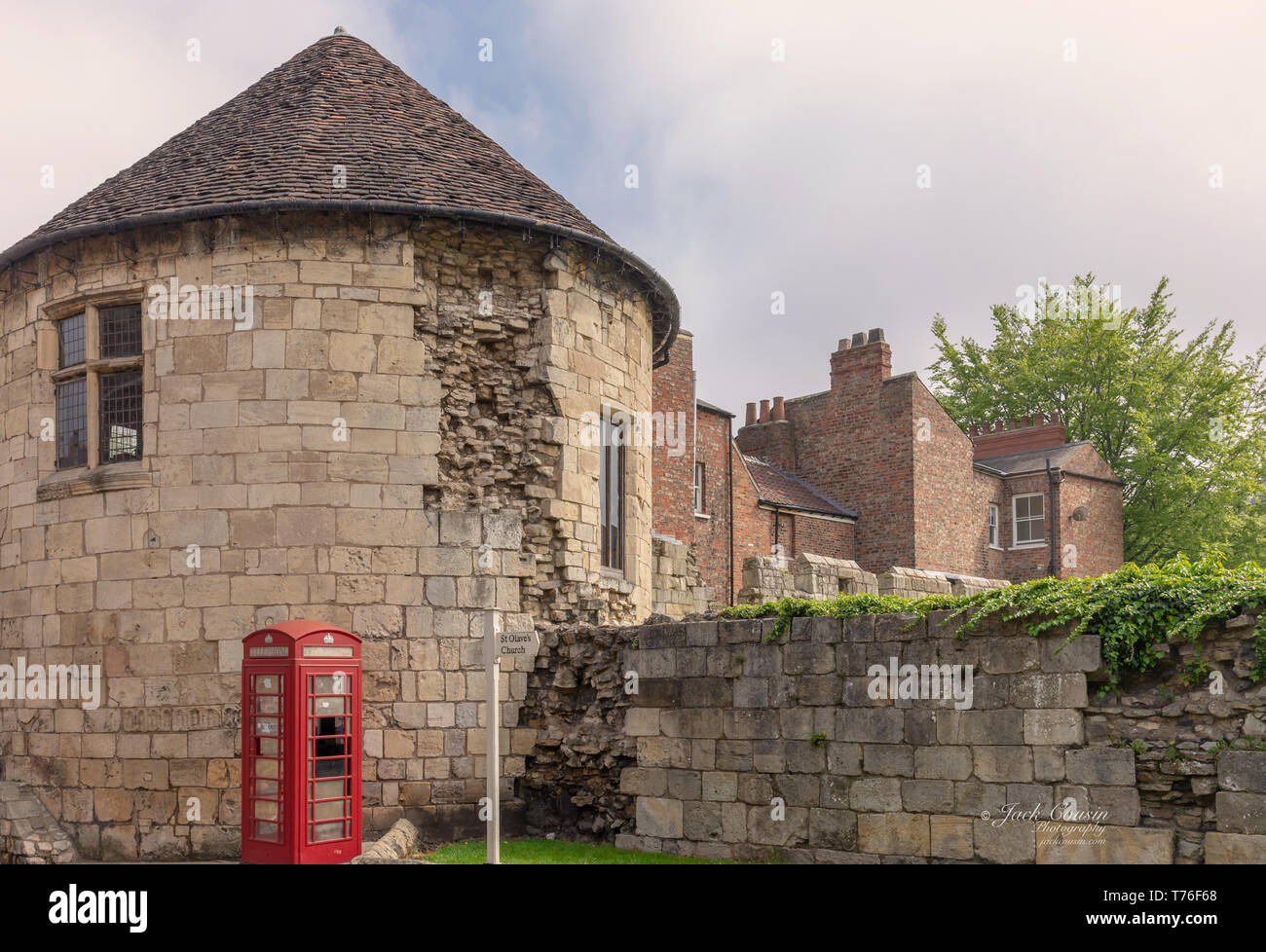 Alte runde Turm in Stadtmauern von York. Die Häuser sind auf der anderen Seite und Es ist ein bewölkter Himmel oben. Stockfoto