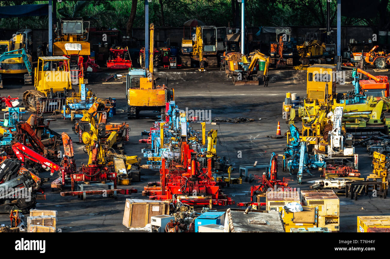 Schwere Maschinen aus zweiter Hand. Kran, Gabelstapler, Bagger, und elektrischen Generator über die dreckigen Betonboden. Lager von schweren Maschinen Stockfoto