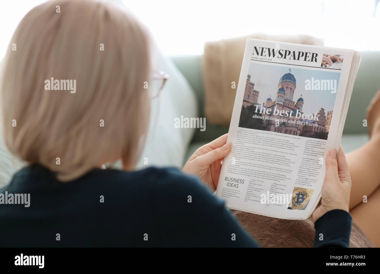 Reife Frau lesen Zeitung zu Hause Stockfoto