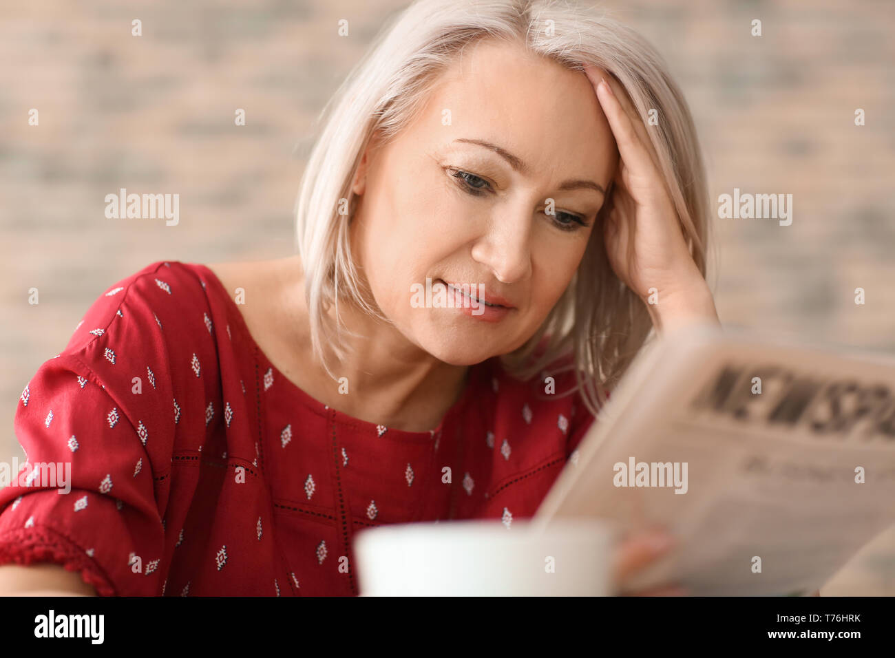 Reife Frau lesen Zeitung im Cafe Stockfoto