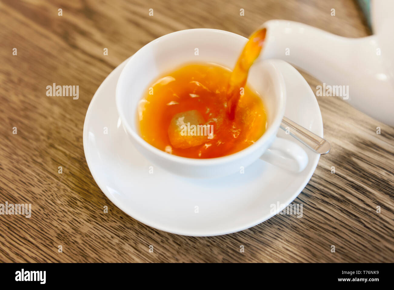 Erhöhte Nahaufnahme der Eingabe von frischem Tee in einem weißen Teetasse. Stockfoto