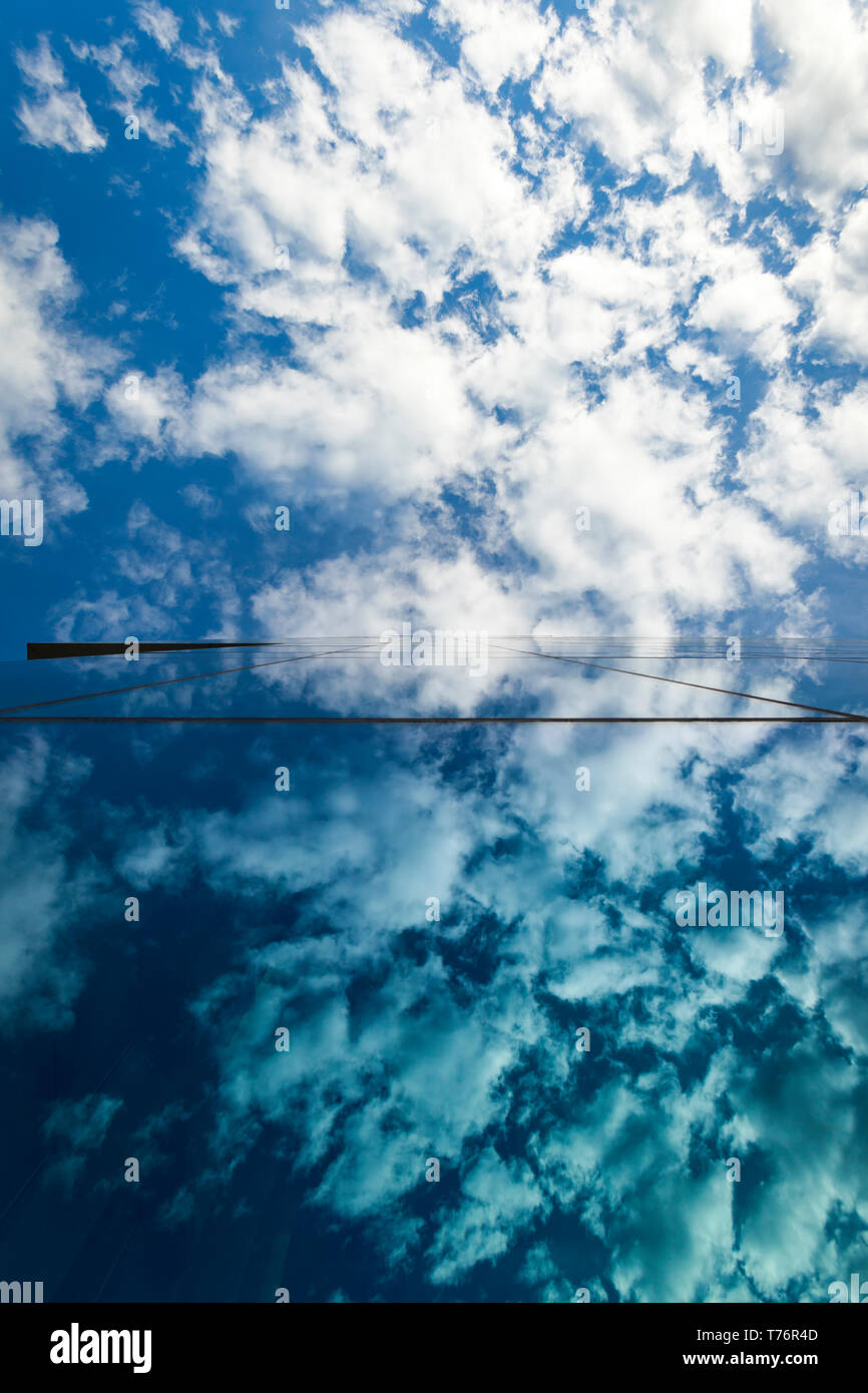 Wolken und blauer Himmel spiegelt sich auf Glas Bürogebäude windows Stockfoto