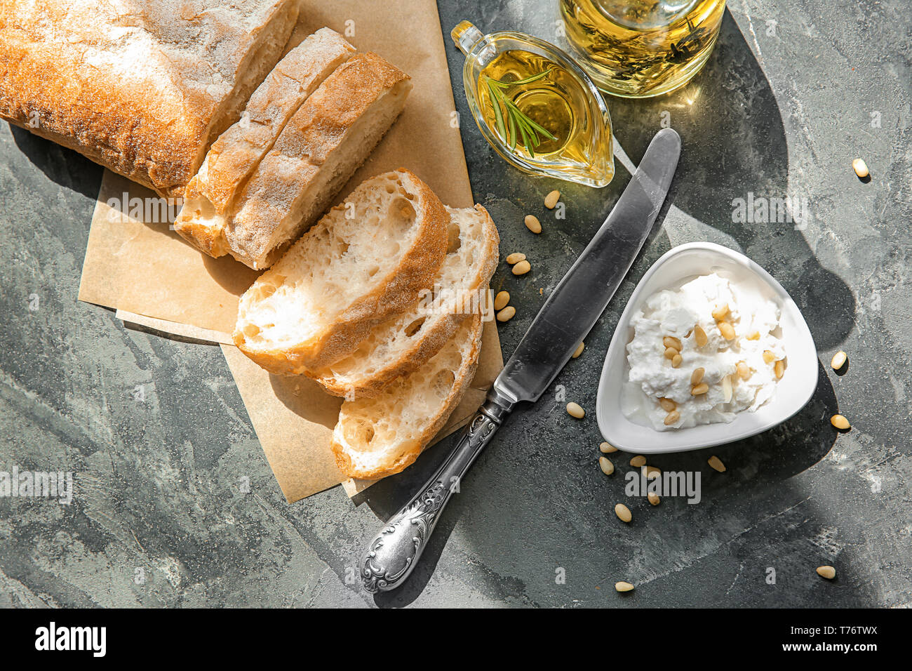 Frisches Brot mit Olivenöl und Frischkäse auf Tisch Stockfoto