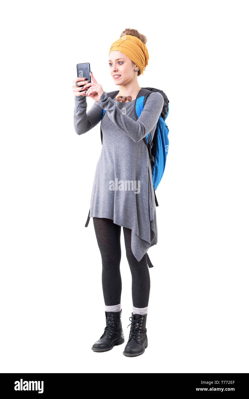 Glückliche junge Hipster touristische Frau mit Rucksack Sightseeing und Machen Fotos mit Smart Phone. Voller Körper auf weißem Hintergrund. Stockfoto