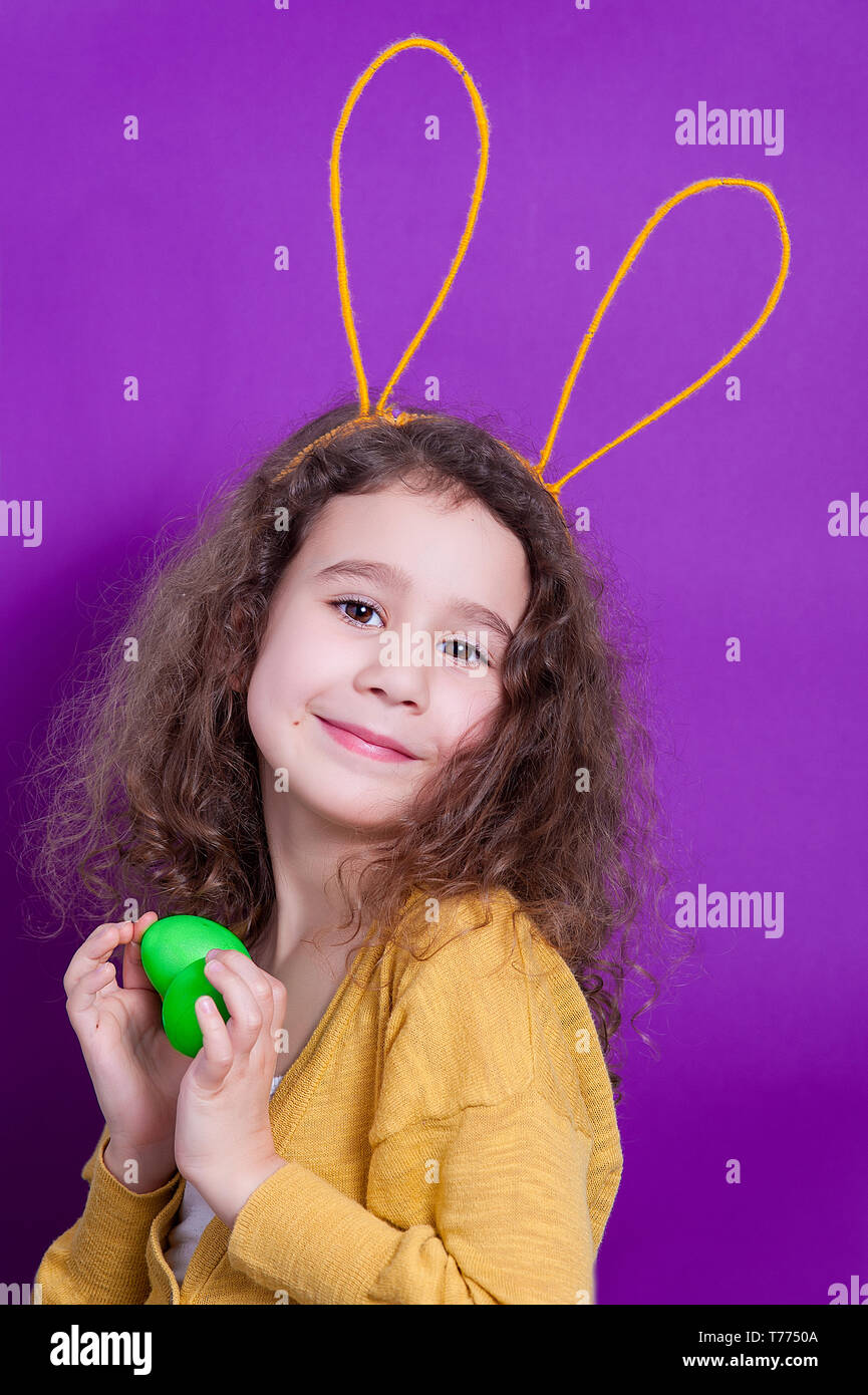 Fröhliche kleine Kind Mädchen mit Hasenohren mit zwei Ostereier auf ... Fröhliche kleine Kind Mädchen mit Hasenohren mit zwei Ostereier auf ...