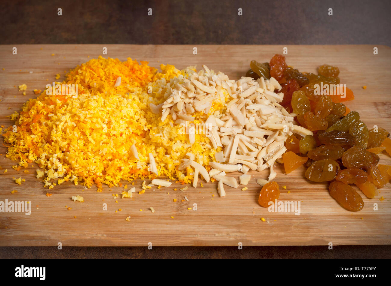 Getrocknete Rosinen, Mandeln und zerdrückten mandarin Muscheln auf Holzbrett über braun Holz- Hintergrund, Ansicht von oben. Close-up. Stockfoto