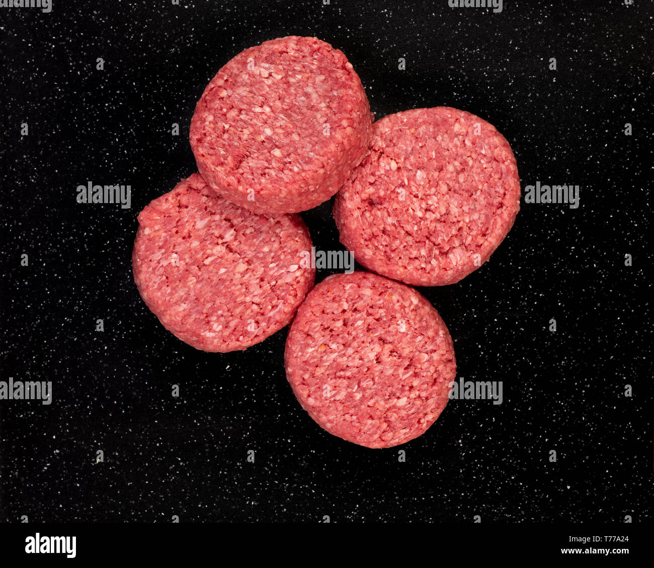 Frische rohe prime Black Angus Beef Burger Pastetchen auf schwarzem Stein. Stockfoto