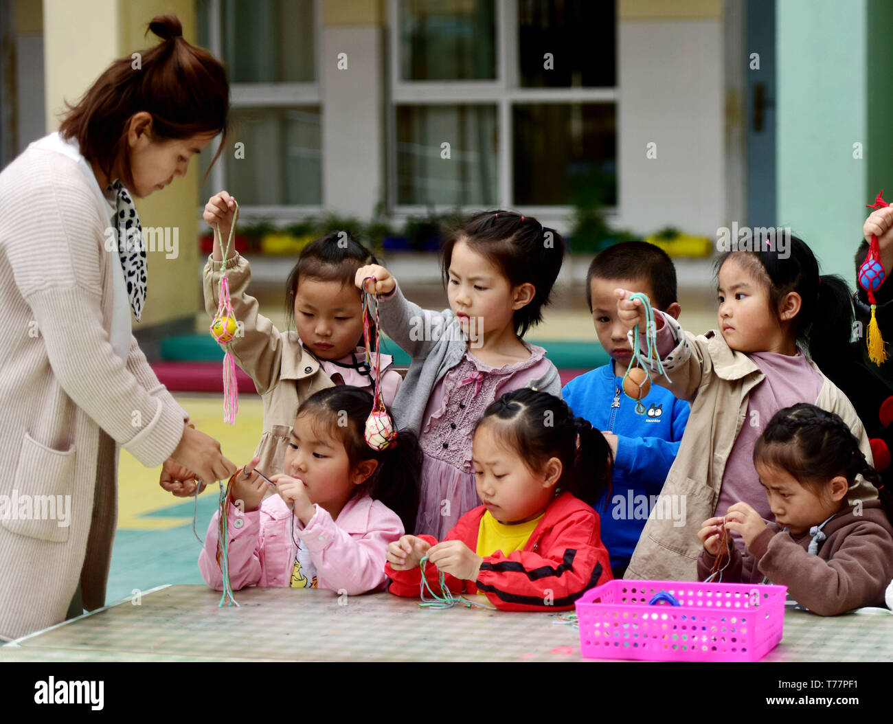 Jinhua, Zhejiang Provinz Chinas. 5 Mai, 2019. Die Kinder lernen, ein Netz für die bemalte Eier unter der Führung eines Lehrers die bevorstehende "STADTBEZIRK", oder Anfang Sommer, Kennzeichnung in einem Kindergarten in Wuyi Grafschaft von Jinhua zu stricken, der ostchinesischen Provinz Zhejiang, 5. Mai 2019. Marken Stadtbezirk siebenten solar Bezeichnung auf dem chinesischen Mondkalender kennzeichnet den Beginn des Sommers. Credit: Zhang Jiancheng/Xinhua/Alamy leben Nachrichten Stockfoto