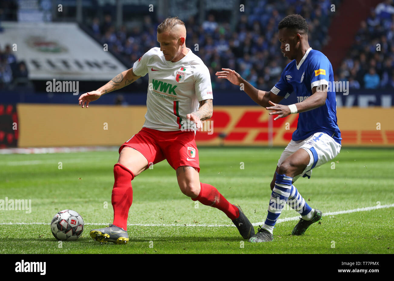 Gelsenkirchen, Deutschland. 05 Mai, 2019. Fussball: Bundesliga, FC Schalke 04 - FC Augsburg 32. Spieltag in der Veltins Arena. Jonathan Schmid (l) aus Augsburg erhält den Ball vor schalkes Rabbi Matondo. Credit: Friso Gentsch/dpa - WICHTIGER HINWEIS: In Übereinstimmung mit den Anforderungen der DFL Deutsche Fußball Liga oder der DFB Deutscher Fußball-Bund ist es untersagt, zu verwenden oder verwendet Fotos im Stadion und/oder das Spiel in Form von Bildern und/oder Videos - wie Foto Sequenzen getroffen haben./dpa/Alamy leben Nachrichten Stockfoto