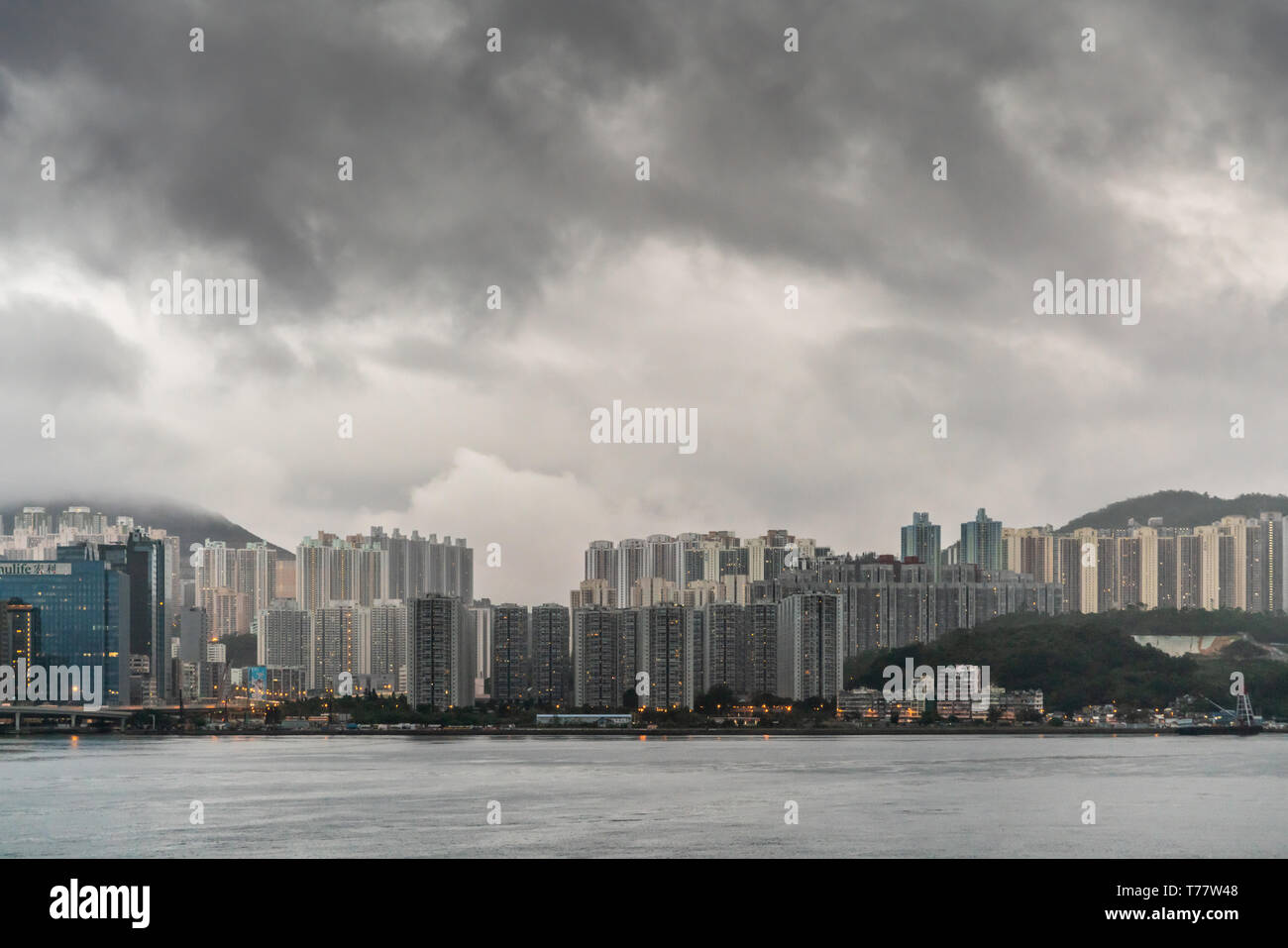 Hong Kong, China - 6. März, 2019: Sehr früh am Morgen unter dunklen regnerischen Himmel. Kowloon Bay Skyline mit hohen Gebäuden von Kwun Tong Gegend. Stockfoto