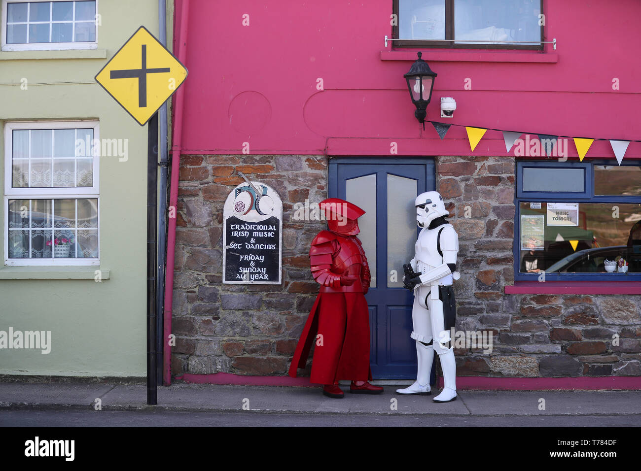Mitglieder der "501st Legion Irland Garnison' gekleidet als Prätorianergarde (links) und ein Stormtrooper auf den Straßen von Portmagee, Kerry, während der Mai der 4. Festival, wo Szenen aus Star Wars gedreht wurden. Stockfoto