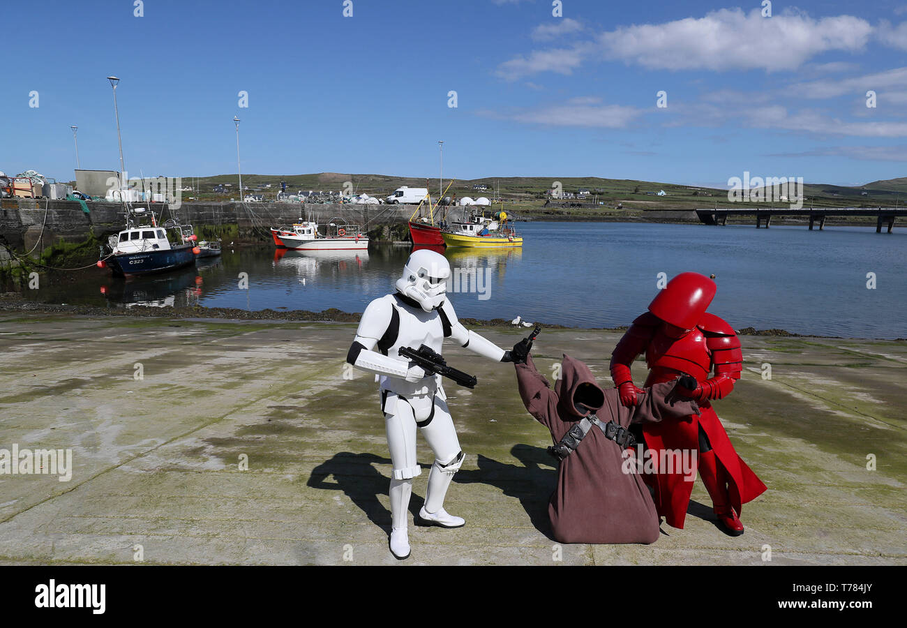 Mitglieder der "501st Legion Irland Garnison' gekleidet als Prätorianergarde (rechts), Stormtrooper (links) und eine Jawa im Hafen von Portmagee, Kerry, während der Mai der 4. Festival, wo Szenen aus Star Wars gedreht wurden. Stockfoto