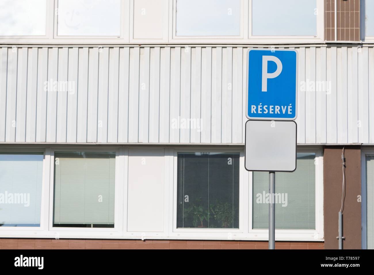 Konzeptionelle parken Schild - finden - mit leeren Arbeitsplatte. Gebäude hinter Stockfoto