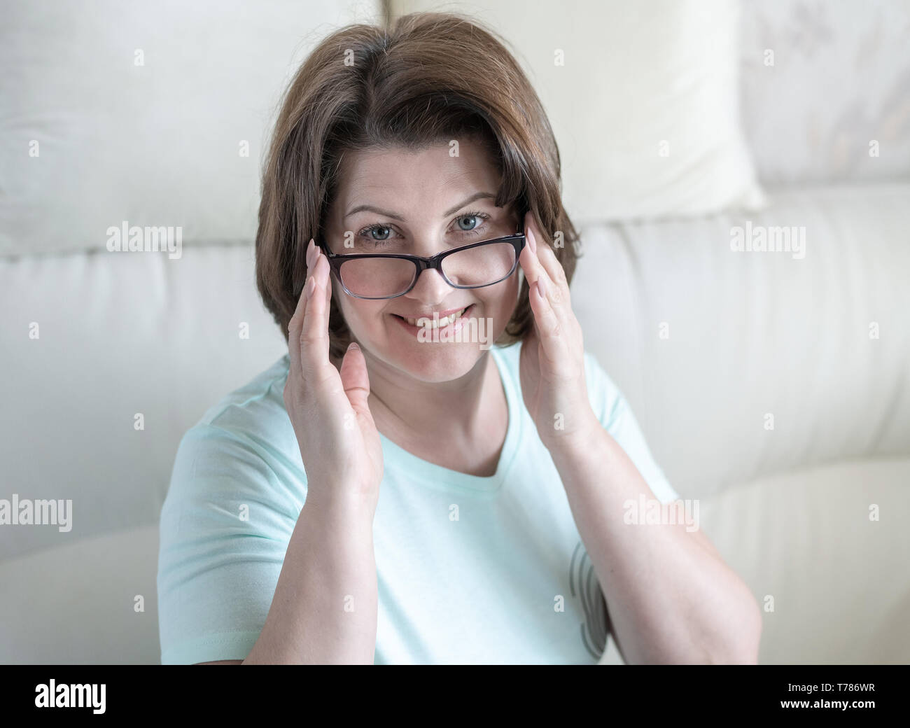 Porträt einer Frau mit Brille in Home Interior Stockfoto