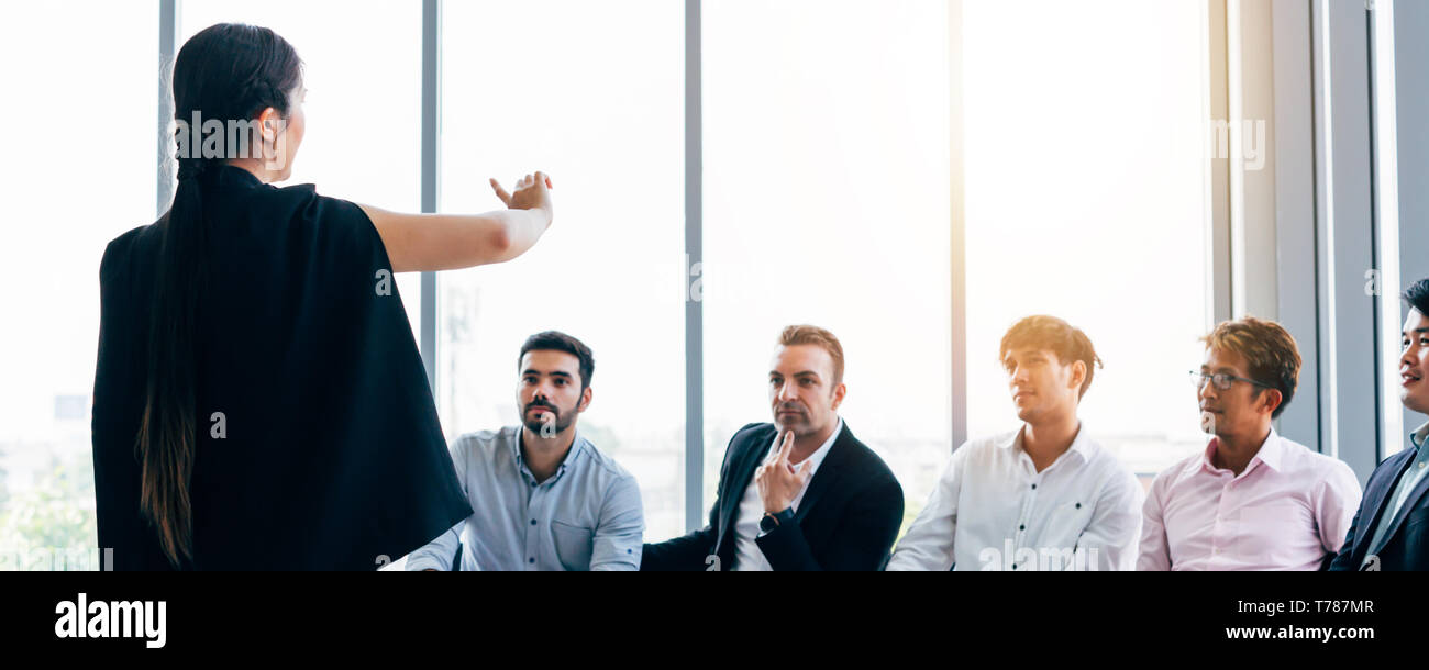 Elegante Frau, Präsentation für die Gruppe der modernen männlichen Kollegen in business meeting in hellen Konferenzraum Stockfoto