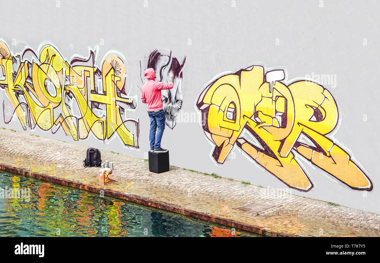 Street Graffiti Künstler Malen mit einem Color Spray kann ein Graffiti an der Wand in der Stadt - Begriff der zeitgenössischen Kunst lifestyle Stockfoto