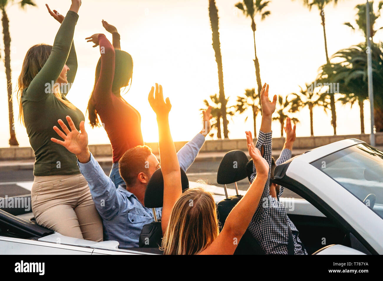 Gerne Freunde Spaß im Cabrio im Urlaub - Junge Leute genießen Zeit mit Reisen und Tanzen in einem Cabrio Auto während Ihres Ausflugs Stockfoto