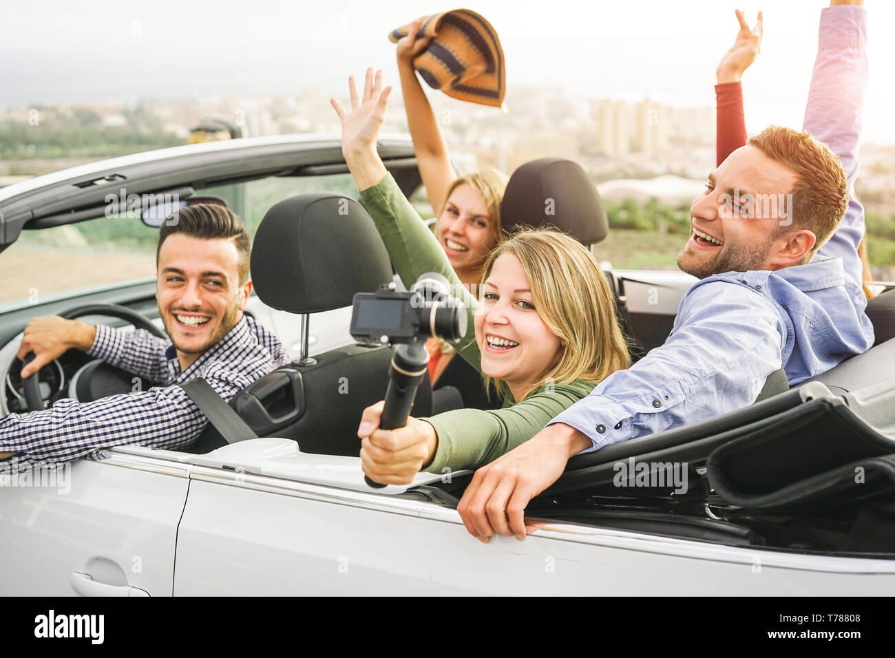 Gerne Freunde Aufnehmen von Fotos mit selfie stick Kamera im Cabrio im Urlaub - junge Menschen, die Spaß im Cabriolet Auto während Ihres Ausflugs Stockfoto